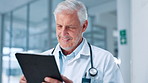 Doctor, healthcare and tablet with man in hospital for review of information or records. Medical, stethoscope and telehealth with mature medicine professional in clinic for cardiology results
