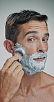 Man, face and beard with brush or cream for shave, hair removal or epilation on a white studio background. Portrait, male person or model with cosmetics, foam or soap for hygiene, grooming or facial