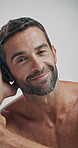 Confident, smile and skincare for man, studio and happy for glow of skin, cosmetics or dermatology. White background, face and person with treatment for wellness, shine or aesthetic for beauty in USA