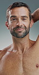 Happy man, face or hygiene with smell for fragrance, scent or aroma on a studio background. Portrait, male person or model with antiperspirant, perfume or smile for armpit, odor mask or body cologne
