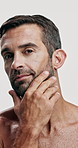 Studio, confident and skincare for man, smooth and facial treatment for glow of skin and dermatology. White background, soft and person with routine for self care, face or cosmetics for beauty in USA