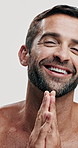 Studio, grooming and skincare for man, cosmetics and facial treatment for moisture of skin, face or dermatology. White background, shine and person with routine for self care, beauty and smile in USA