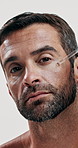 Man, serum and beauty with face skincare, hand and moisturizer with hyaluronic acid or cosmetic product. Portrait, male person with oil or liquid collagen for skin health on white studio background