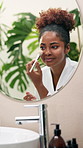 African woman, makeup brush and mirror in bathroom, smile and foundation for beauty in morning at apartment. Girl, person and tools for powder, cosmetics or happy for results with reflection in home