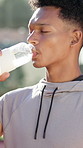 Man, drinking water and bottle at tennis court for fitness, hydrate and break in summer for padel game. Person, athlete and liquid for benefits, rest and tired at training for competition in Colombia