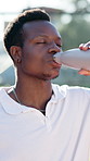 Black man, water and drinking with bottle for sport, hydration or break on tennis court. Male person, rest or thirst with mineral liquid or nutrition for natural sustainability, match or performance
