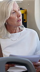 Window, thinking and woman in bus, travel and commuting to work with documents, employee and serious. Reflection, passenger and mature person with paperwork in public transport, reading and vehicle