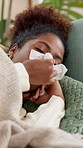Sick, black woman and blowing nose with tissue for virus, disease or viral infection on sofa at home. Female person, cough or lying with influenza for sinus, hayfever or allergies on couch at house