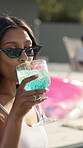 Toast, party and woman with cocktail in swimming pool for weekend, break or vacation. Relax, sunglasses or girl in water with smile, drink and alcohol at hotel or lodge resort for summer getaway