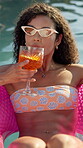 Inflatable, cocktail and woman with holiday in swimming pool for weekend, break or vacation. Relax, sunglasses or girl in water with drink, travel and rest at hotel or lodge resort for summer getaway