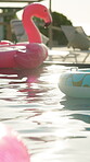 Flamingo, float and swimming pool of hotel in summer for hospitality, outdoor fun or relaxation. Luxury, travel and water with inflatable rings at resort for holiday, vacation and weekend getaway