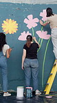 Women, painter and back with group for mural, flowers and art project for community in town. Girl, people and friends with charity for social responsibility, design or volunteer by building in city
