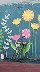 Painting, wall art and ladder with flower design for exterior decoration, community service or charity. Empty, space and colorful surface with creativity for DIY campaign, message or mural activity