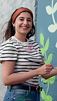 Happy woman, face and artist with wall art for floral design, colorful creativity or community service. Portrait, female person or volunteer with paint or smile for flower, mural activity or charity