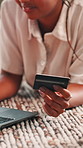 Credit card, laptop and woman on floor for online shopping, purchase and payment in home. Ecommerce, typing info and person on computer for website sale, discount and internet banking in living room