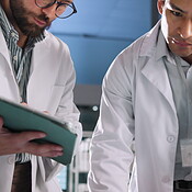 Innovation, scientist and men with tablet, lab and medical research ...