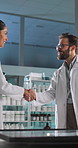 Scientist, man and woman with handshake in lab with smile by interactive display for welcome at pharma company. People. shaking hands and happy with introduction, respect or deal for medical research