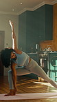 Warrior pose, yoga and woman with flexibility for fitness, balance and calm with stretching in home. Health, wellness and African yogi person for workout, exercise and holistic self care in kitchen