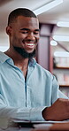 Education, student and man with smile, library and laughing at research for project, learning and college. Knowledge, learner and black person with info for history test, happiness and preparation