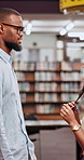 University, friends and conversation at school in library for research, college education or knowledge with books. Man, woman and students in campus for flirting, crush and studying for scholarship