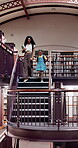 Woman, child and walking with books in library for information, learning and academic knowledge. Teacher, student and holding hands with education resources, project research and homework on stairs