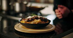 Hands, person and plate with food in kitchen for presentation, lunch served and dining aesthetic. Chef spin board and professional cooking, gourmet pasta and meal prep decoration for catering service