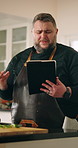 Man, home and question in kitchen with tablet, doubt or confused as entrepreneur. Male person, issue and tech for tutorial, frustrated research or recipe for private chef cooking or meal preparation