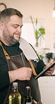 Smile, man and chef with tablet in kitchen for research, review website and tips for cooking recipe. Male person, digital and online of cuisine information, food guide and dinner preparation at house