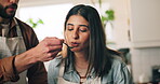 Couple, cooking and feeding food in kitchen with meal preparation, helping and nutrition lunch. People, chef and tasting recipe with healthy ingredients, gourmet cuisine and bonding together at house