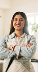 Happy woman, face and chef with confidence in kitchen for hospitality or catering service at house. Portrait, female person or private cook with smile, apron or arms crossed for homemade culinary