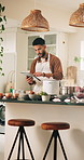 Man, chef and tablet with ingredients for online recipe, cooking tutorial or tips at home. Male person, research and technology with checklist or app for hospitality, catering or food preparation