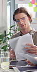 Man, paperwork and report for meeting at startup, review and planning for proposal at tech company. Person, documents and check stats with talking, insight and project management in office at agency