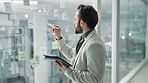 Businessman, writing and planning with tablet on glass board for schedule, agenda or project tasks. Man, employee or planner with technology, ideas or sticky notes for mindmap or brainstorming work