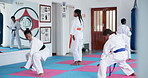 Kids, learning karate and training to exercise for fight, fitness or self defense in class. Students, children and people practice martial arts with instructor for kick, lesson and workout in dojo