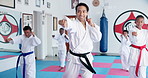 Kids, learning karate and training with instructor for fight, fitness or self defense class. Students, teacher and people practice martial arts for kick, punch or children exercise for lesson in dojo