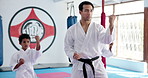 Children, learning karate and training with teacher for fight, fitness lesson or self defense class. Students, instructor and people practice martial arts for exercise, teaching or help kids in dojo