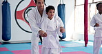 Teaching karate, kid and training with instructor for fight, fitness lesson or self defense class. Students, teacher and people practice martial arts for exercise, coaching or help children in dojo