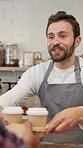 Coffee, man and barista serving in cafe for customer service, hospitality or career in morning. Happy, startup and male server with caffeine order for client by counter for sale in restaurant.