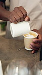 Person, hands or barista with coffee or froth for latte, espresso or cappuccino on cafe counter. Closeup, bistro or heart shape foam with caffeine or hot beverage for cafeteria service or hospitality