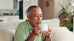 Home, hot coffee and senior man on sofa, relax and blowing with espresso, morning and retirement. Pensioner, apartment and elderly person on couch, herbal tea and warm drink with wellness in lounge