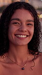 Happy, face and woman on holiday at beach for travel adventure, weekend break and tropical vacation. Dusk, girl and smile outdoor with confidence for getaway, relax and fresh air with wellness 