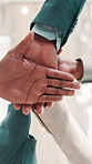 Business people, meeting and huddle with hands together below for teamwork or motivation at office. Low angle, group or employees piling with stack or applause in solidarity for community or mission