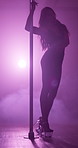 Smoke, spotlight and pole dancing with woman at night for stripper, exotic performance and club. Neon, seductive and private dancer with person in studio for burlesque, entertainment and stage