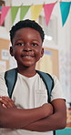 Face, confidence and happy African kid in school for learning, education and youth development. Portrait, smile and boy child in class with arms crossed for growth, scholarship and elementary student