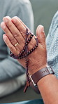 Prayer hands, rosary and religion in home, couple and together for support with faith in living room. Senior people, spiritual jewelry and crucifix for worship, gratitude and Jesus Christ at house