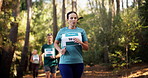 Runner, fitness and woman in forest for exercise, marathon training and cardio workout. Group, nature and athlete in woods for wellness, healthy body and endurance with race challenge or competition