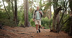 Hiking, senior man and walk in woods for fitness adventure, retirement hobby and cardio wellness. Mature person, relax and journey with backpack for trekking, explore or holiday sightseeing in forest