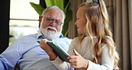 Grandfather, happy child and learning with tablet in home, scroll and play game online. Grandparent, kid and girl with technology in living room for education app, entertainment and bonding together