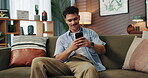 Sofa, man and smile with smartphone for communication, reading message and text from online contact. Home, male person and social media with mobile for application, dating website and chat on couch