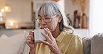 Senior, woman and drinking coffee with thinking on sofa for daydreaming, remember memory and peaceful in retirement. Elderly person, smile and beverage in home with reflection, nostalgia or wondering